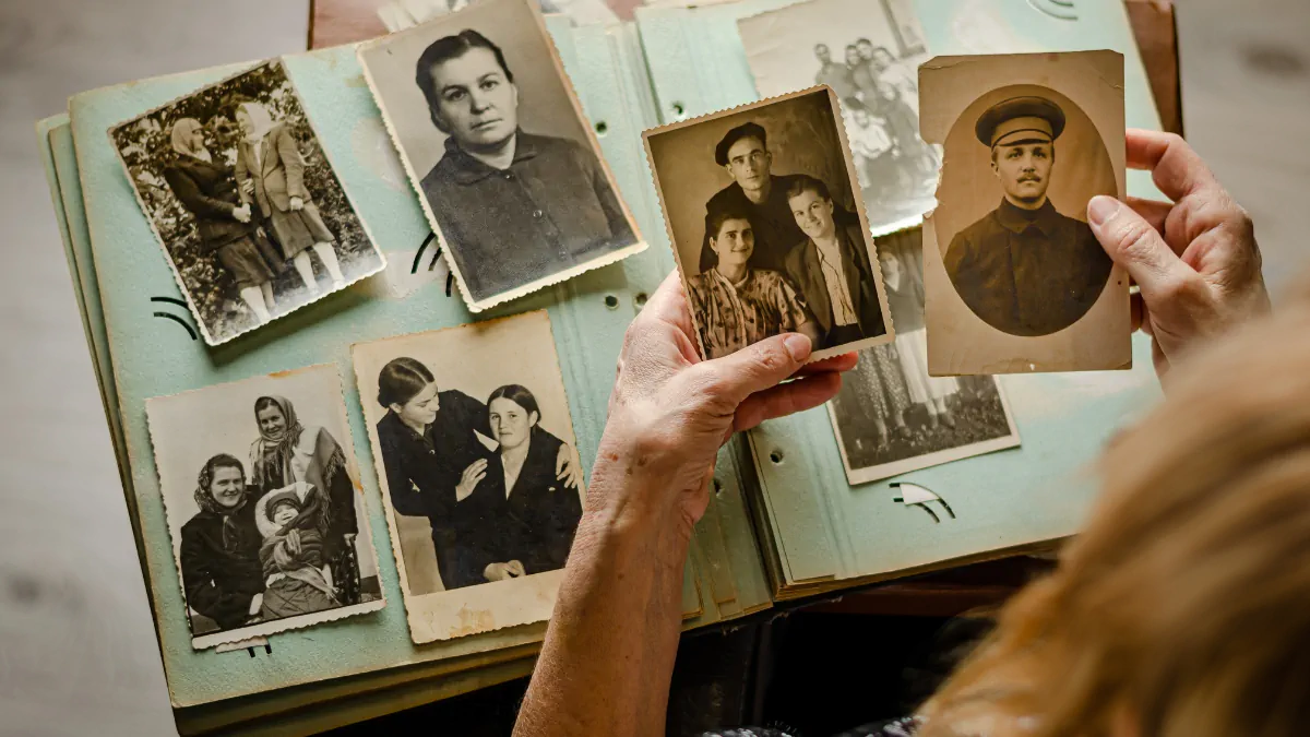 Tips for new Genealogists a genealogist putting photos in an album